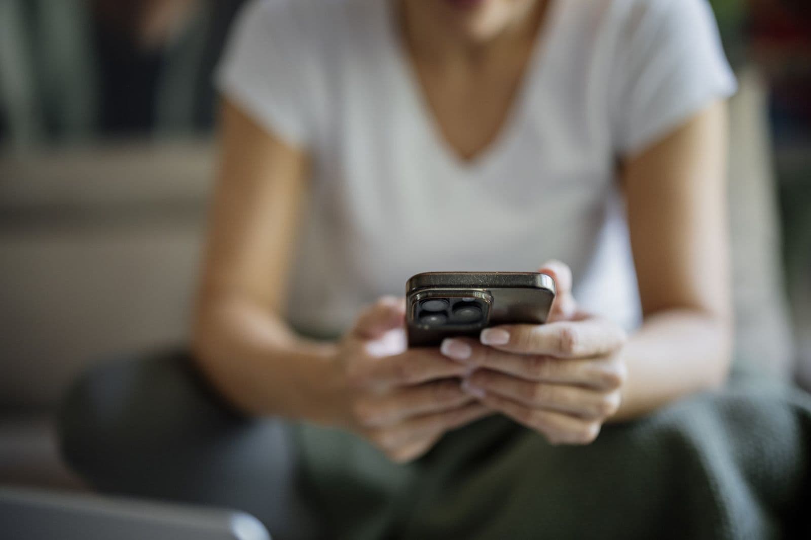 Personne qui suit une course sur son smartphone depuis son canapé. Photo : Shixart1985 / Wikimedia Commons, CC BY 2.0