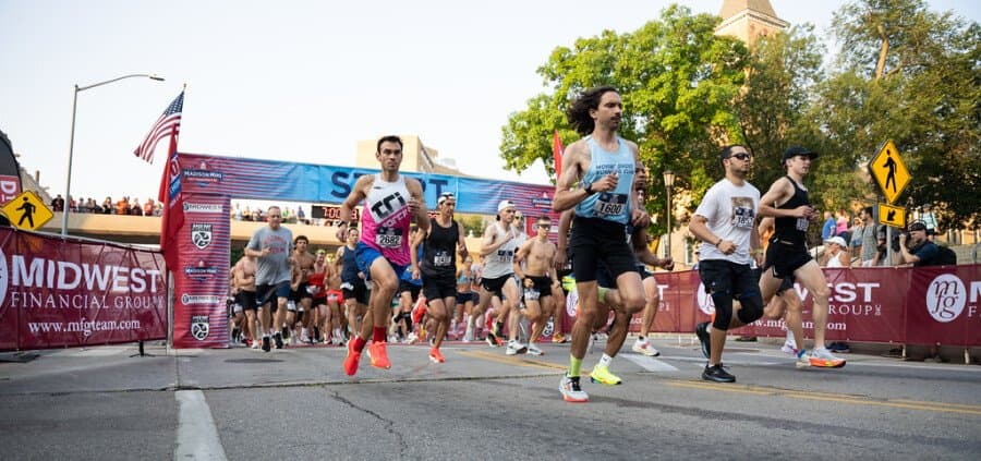 Départ de la course avec les coureurs s'élançant devant le Capitole de Madison et les bannières Midwest Financial Group.