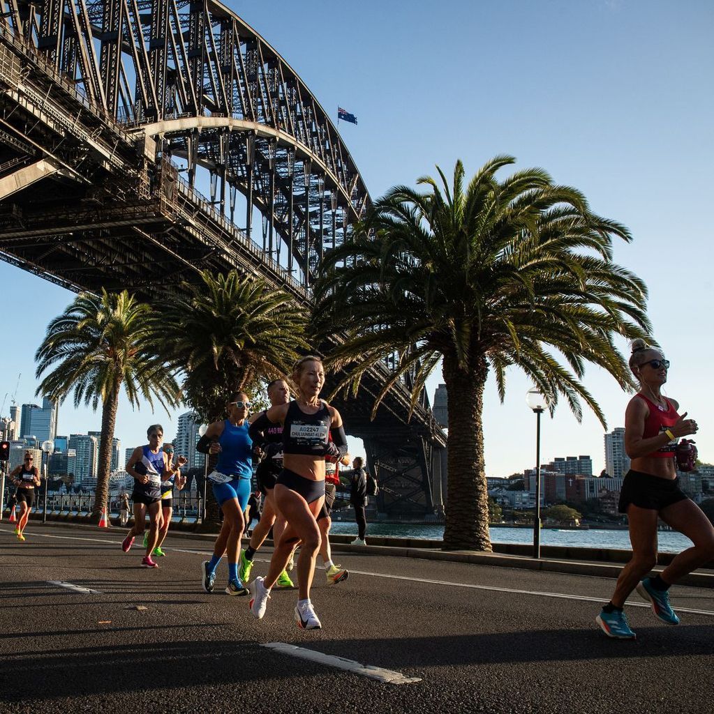 Coureuses en action près du Sydney Harbour Bridge lors du TCS Sydney Marathon dans une ambiance matinale.