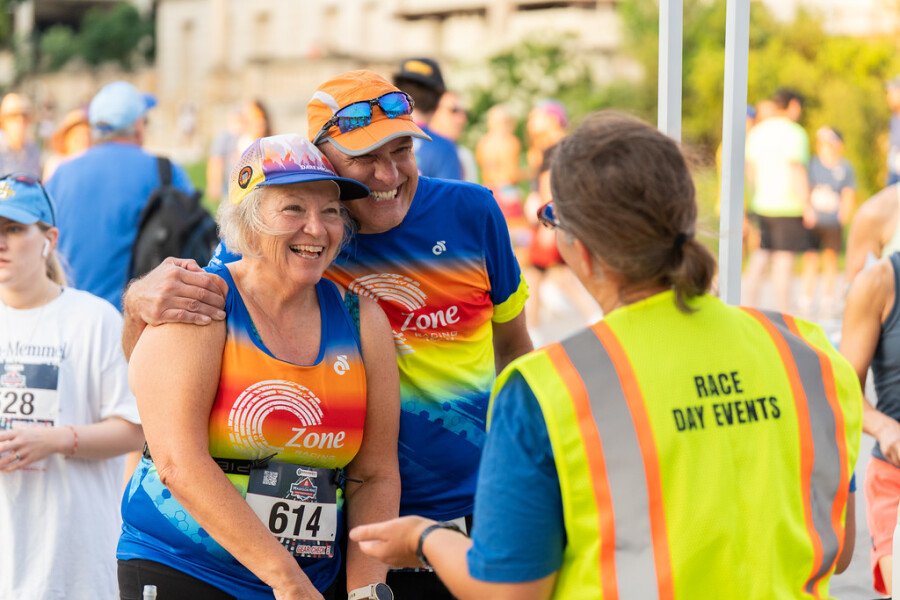 Deux coureurs souriants après leur arrivée au Madison Mini Marathon dans une ambiance conviviale.