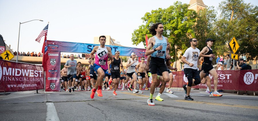 Départ de la course avec les coureurs s'élançant devant le Capitole de Madison et les bannières Midwest Financial Group.