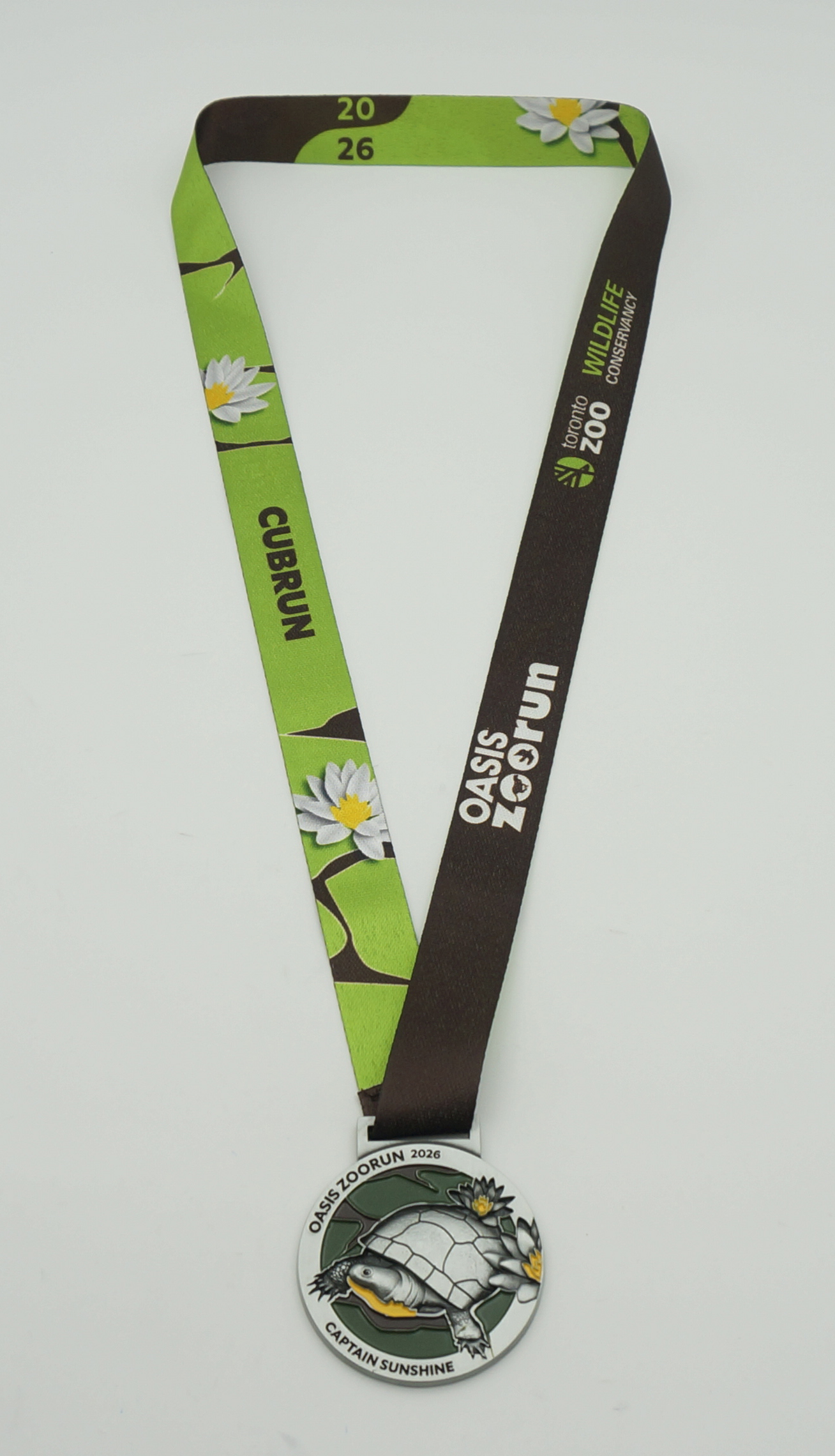 Médaille de finisher de l'Oasis ZooRun 2026 avec son design de tortue et son ruban aux couleurs de la course.