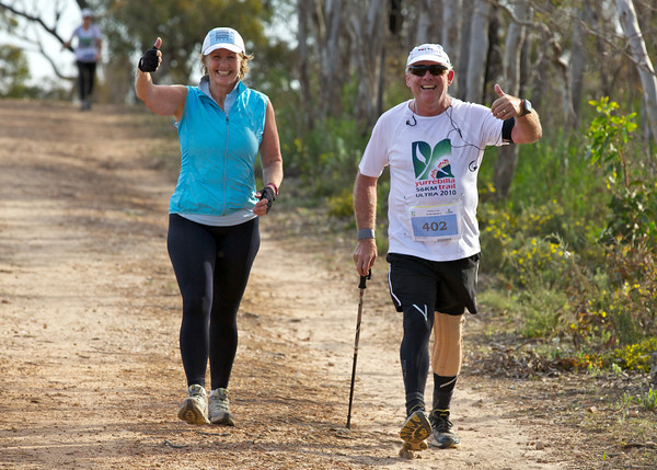 Deux participants souriants et enthousiastes sur le parcours du Yurrebilla Ultra Marathon dans un environnement boisé.